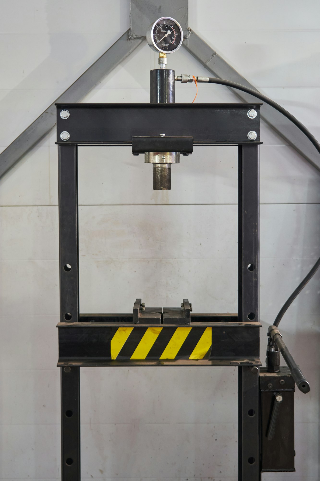 black floor press with manual hydraulic drive. equipped with a pressure gauge